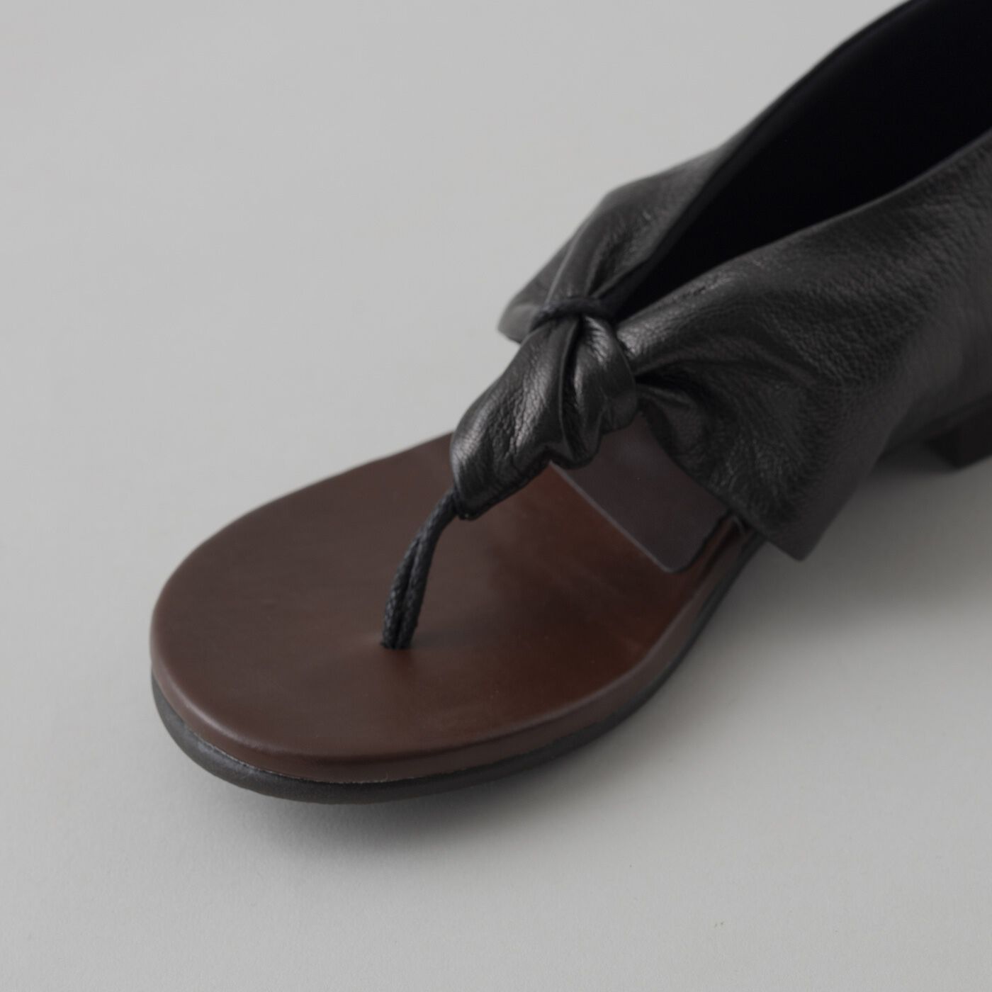 ＆Stories|靴デザイナーの理想で作った　職人本革のスクイーズトング〈ブラック〉|名前の「スクイーズ / squeeze」は「絞る」の意味から。しなやかなレザーをキュッと絞ったようなデザインは、カジュアル感の中にもモードな雰囲気が漂います。