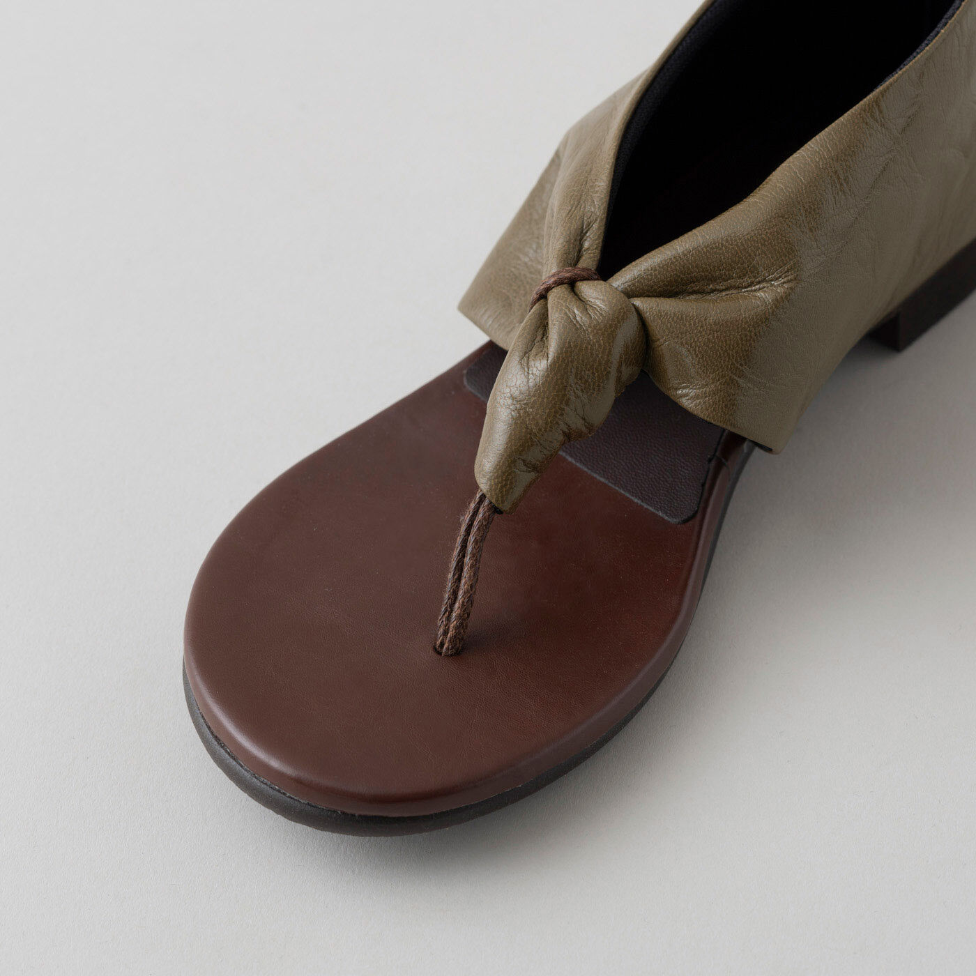 ＆Stories|靴デザイナーの理想で作った　職人本革のスクイーズトング〈オリーブ色〉|名前の「スクイーズ / squeeze」は「絞る」の意味から。しなやかなレザーをキュッと絞ったようなデザインは、カジュアル感の中にもモードな雰囲気が漂います。