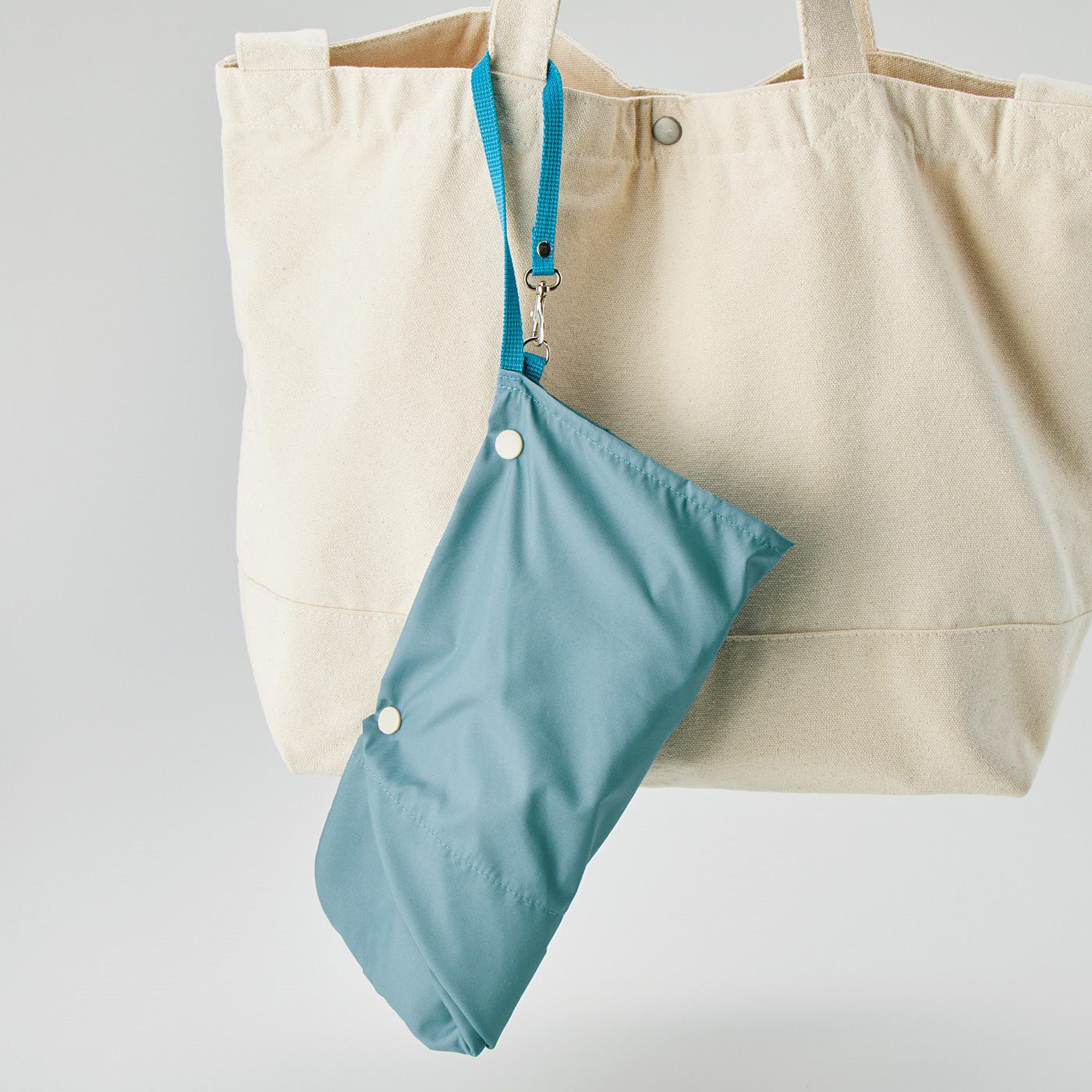 フェリシモの雑貨 Kraso|ぬれたままさっと閉じて収納　幅が広いから入れやすい防水折りたたみ傘ケースの会|ストラップを持ち手に通せば、バッグに付けられます。