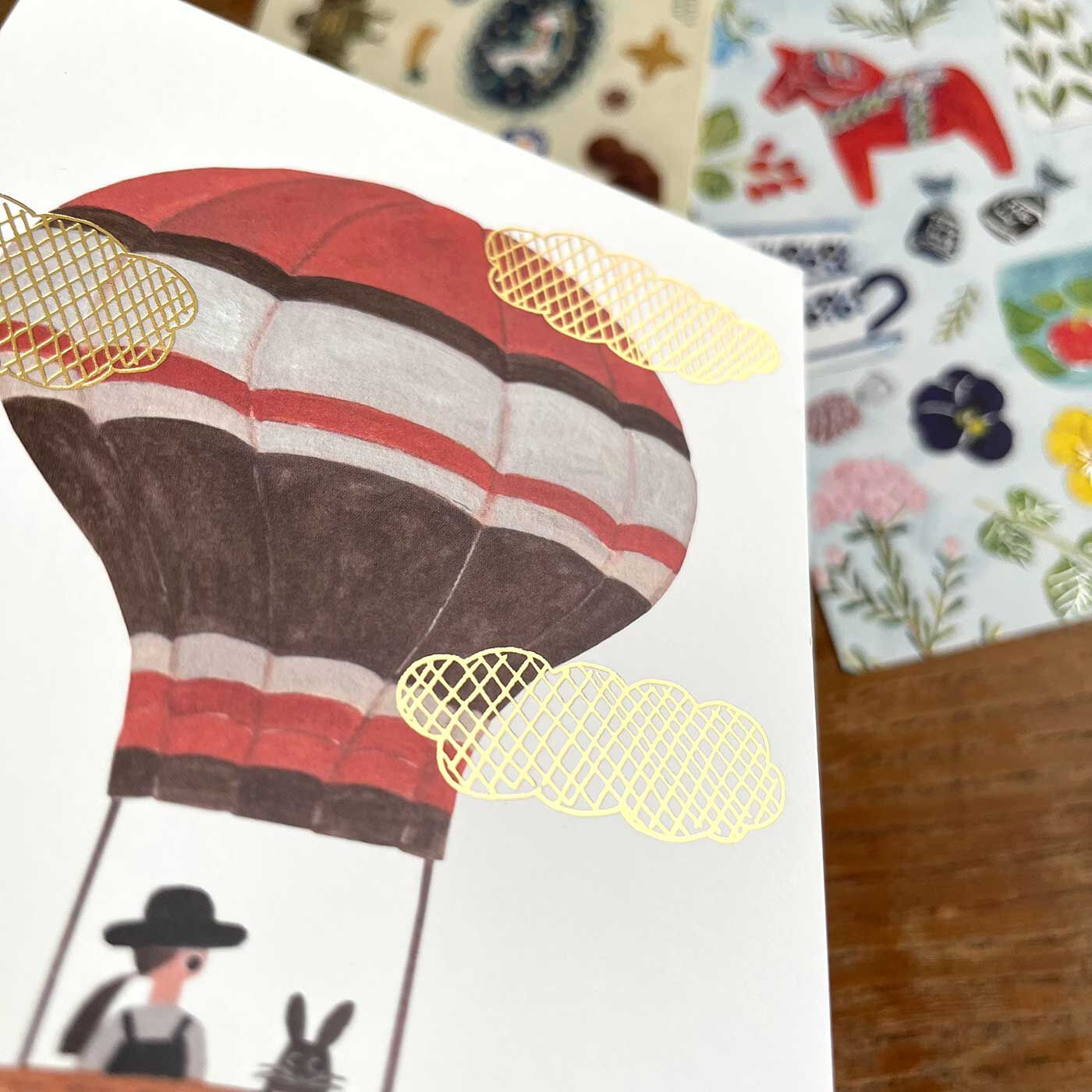 フェリシモの雑貨 Kraso|cozyca products 人気の紙もの文具３点セットの会|【ポストカード】イラストに箔押しが輝く、存在感のある美しいポストカード。作品として飾って楽しむのもいいなぁ。額縁に入れても素敵。